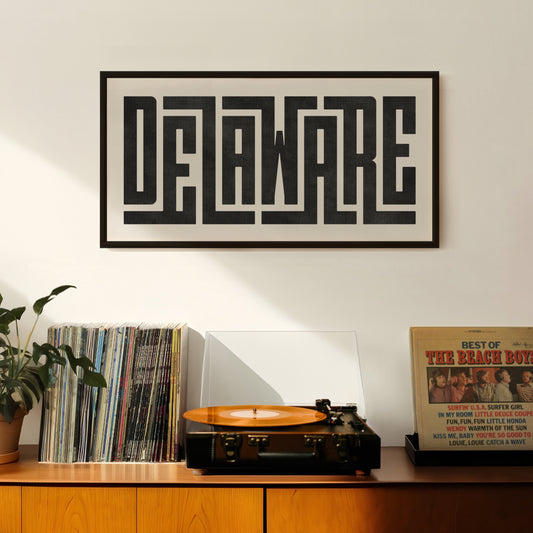 Retro Delaware artwork above vintage record player on Mid-Century Modern furniture.