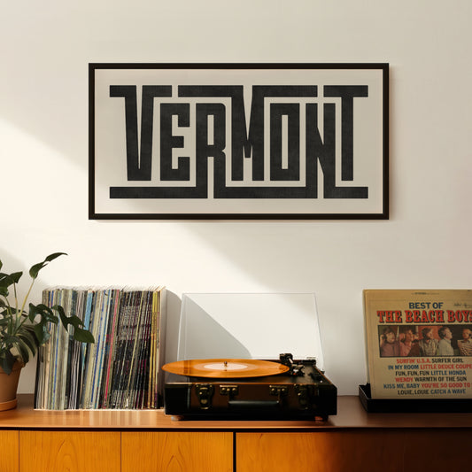 Retro Vermont artwork above vintage record player on Mid-Century Modern furniture.
