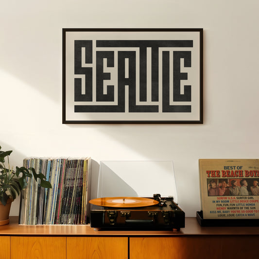 Retro Seattle artwork above vintage record player on Mid-Century Modern furniture.