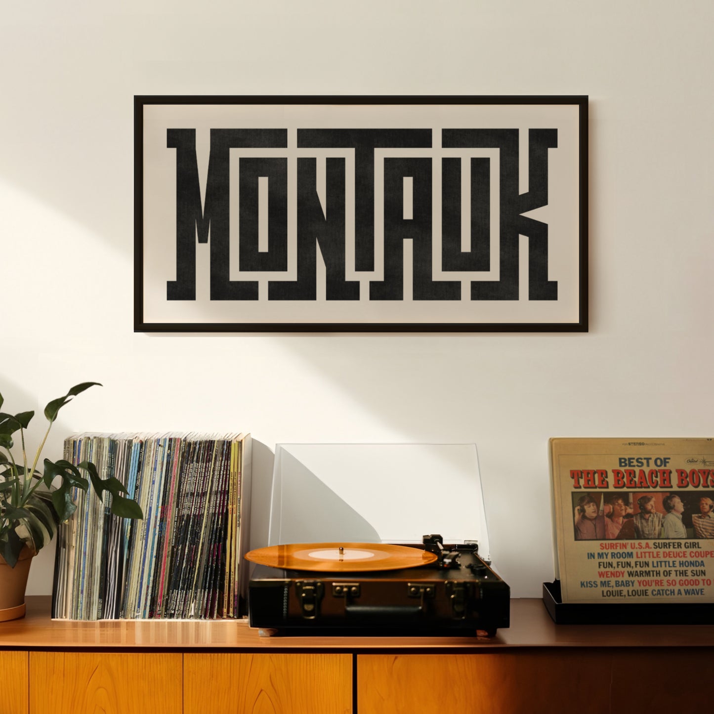Retro Montauk artwork above vintage record player on Mid-Century Modern furniture.