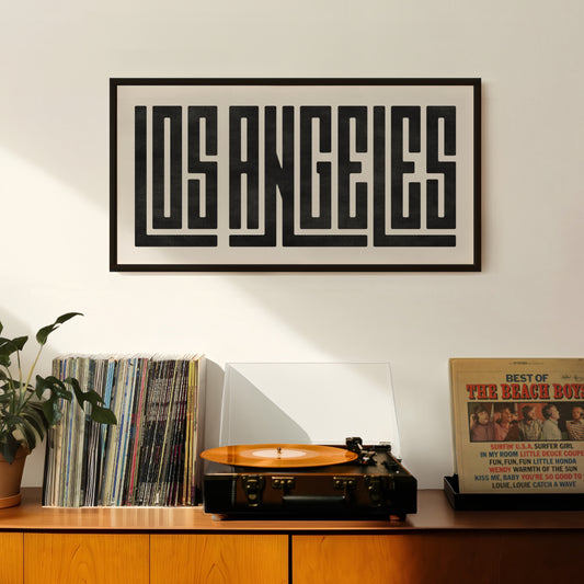 Retro Los Angeles artwork above vintage record player on Mid-Century Modern furniture.