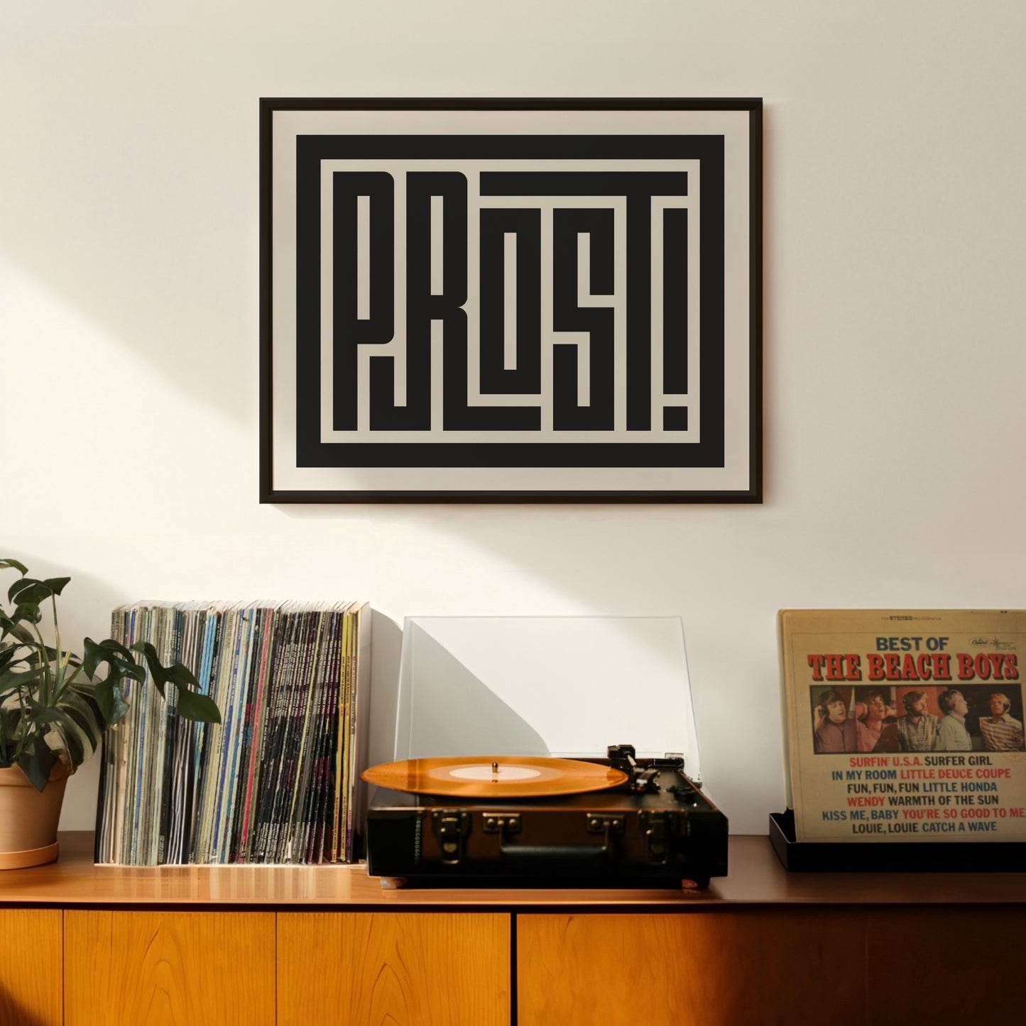 Retro Prost artwork above vintage record player on Mid-Century Modern furniture.