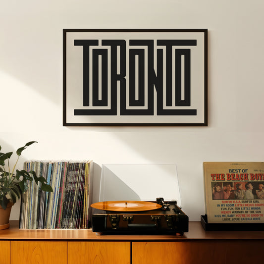 Retro Toronto artwork above vintage record player on Mid-Century Modern furniture.