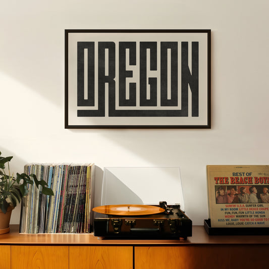 Retro Oregon artwork above vintage record player on Mid-Century Modern furniture.