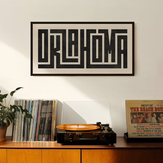 Retro Oklahoma artwork above vintage record player on Mid-Century Modern furniture.