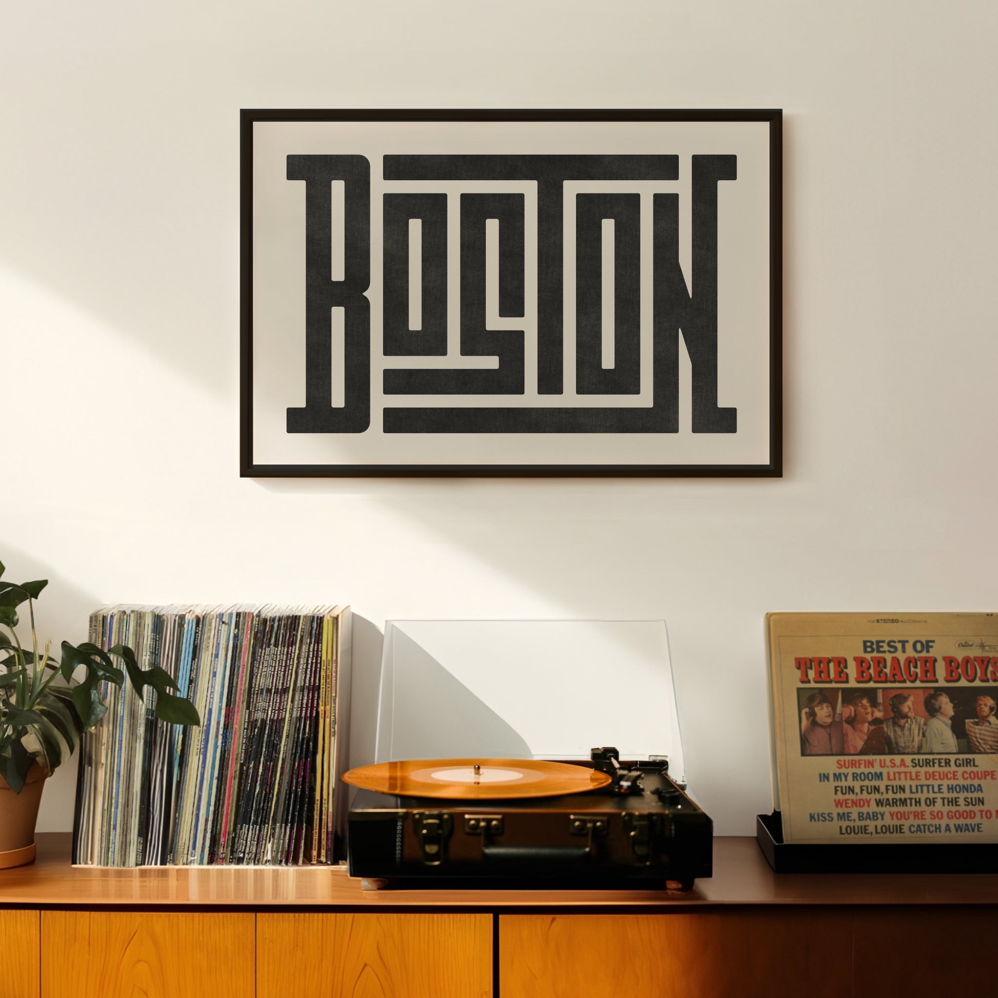 Retro Boston artwork above vintage record player on Mid-Century Modern furniture.