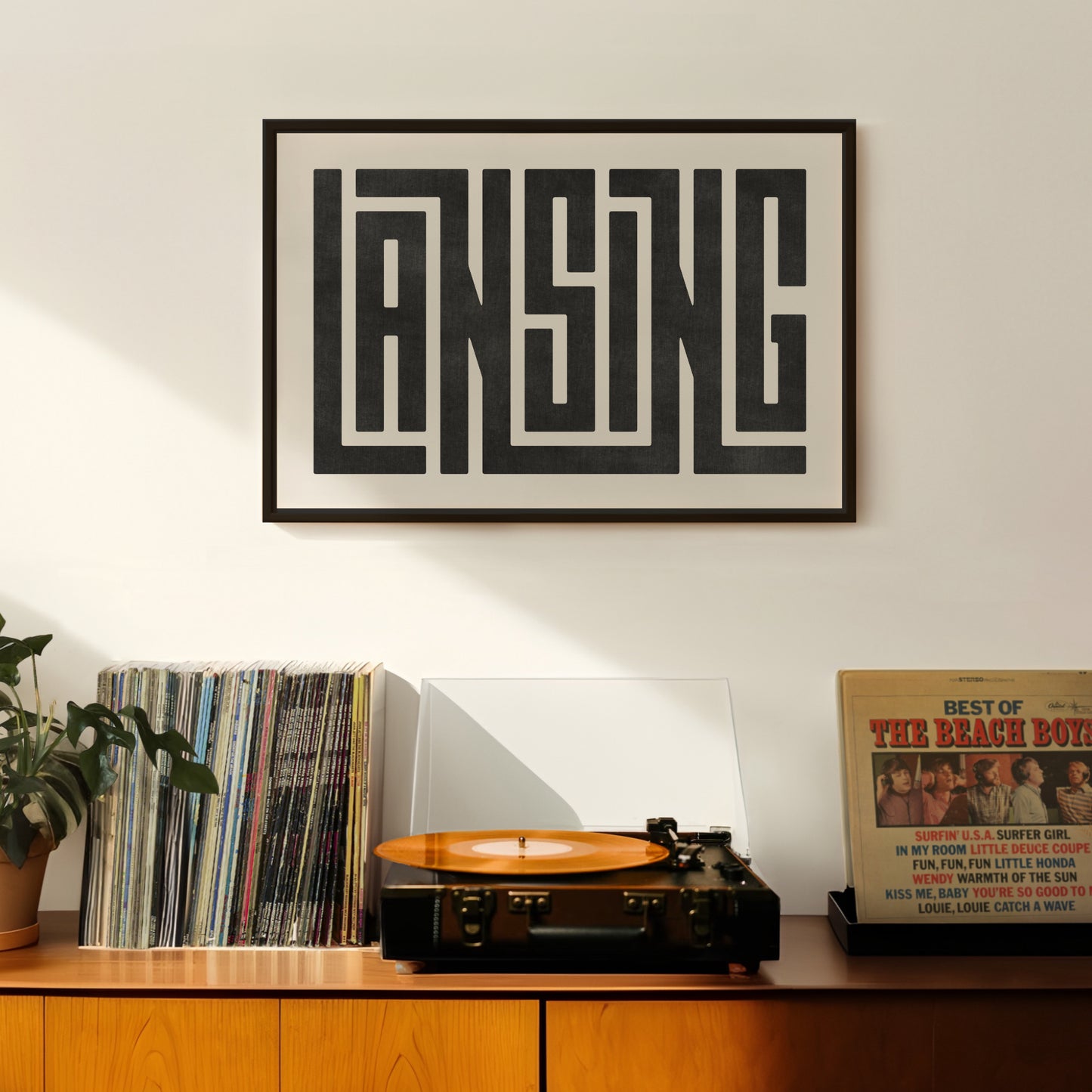 Retro Lansing artwork above vintage record player on Mid-Century Modern furniture.