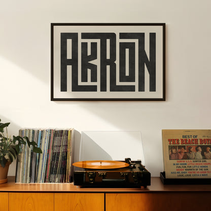 Retro Akron artwork above vintage record player on Mid-Century Modern furniture.