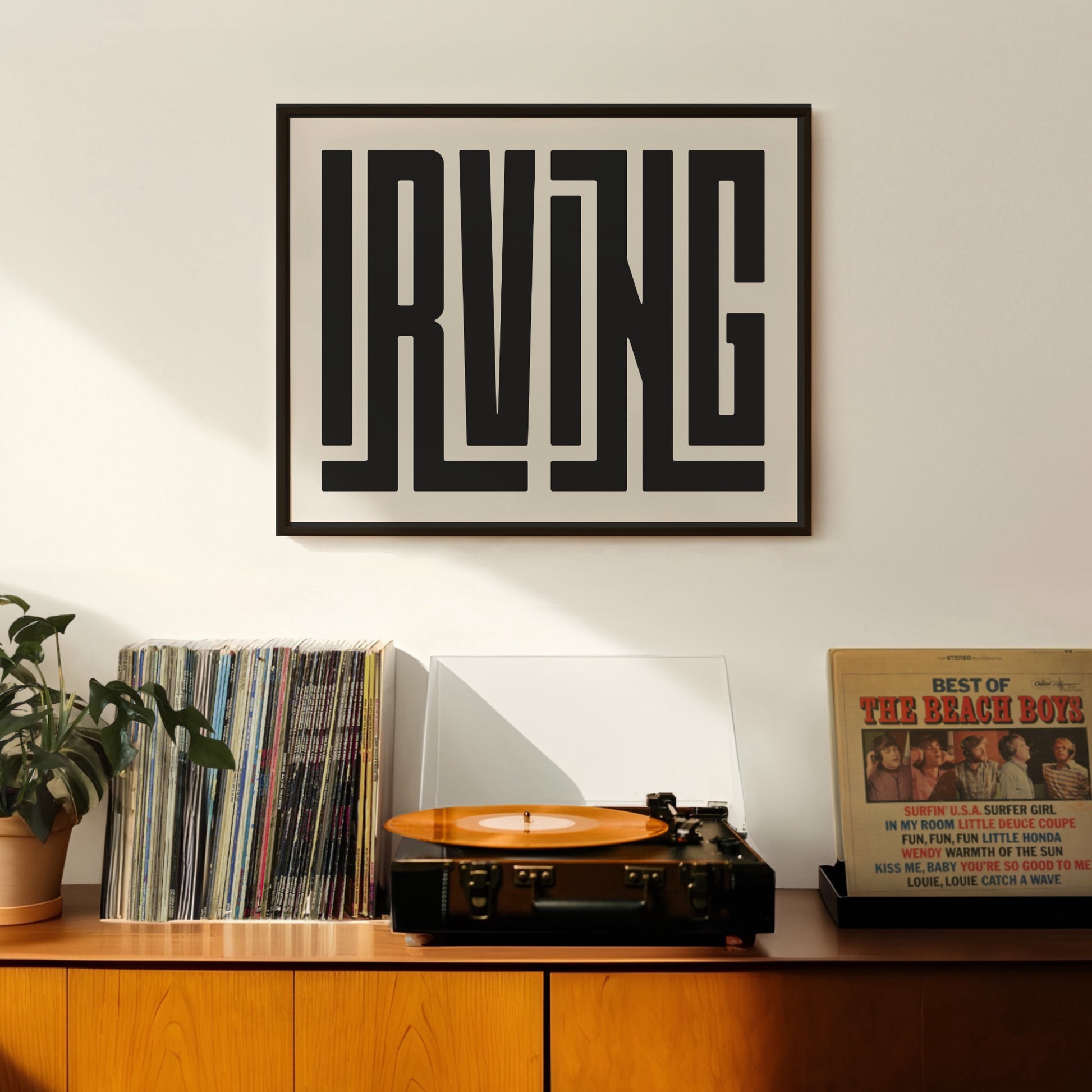 Retro Irving artwork above vintage record player on Mid-Century Modern furniture.