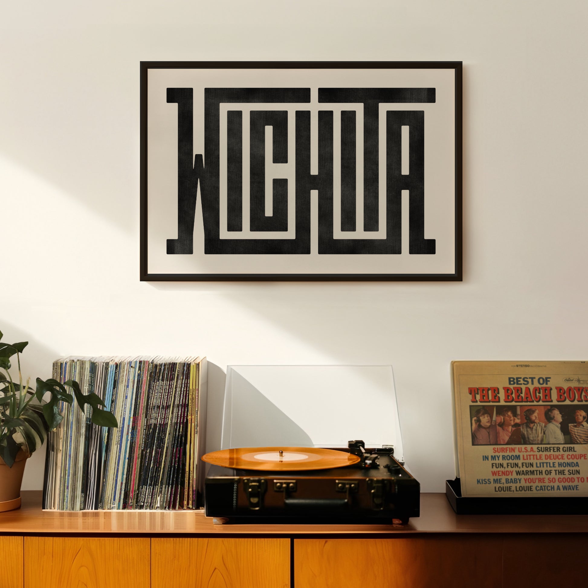 Retro Wichita artwork above vintage record player on Mid-Century Modern furniture.
