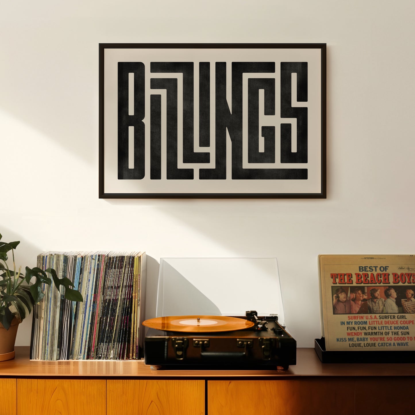 Retro Billings artwork above vintage record player on Mid-Century Modern furniture.