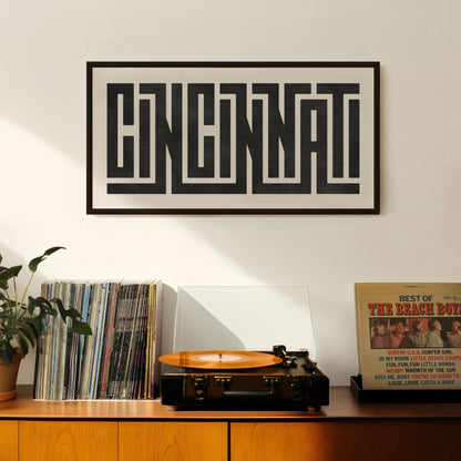 Retro Cincinnati artwork above vintage record player on Mid-Century Modern furniture.