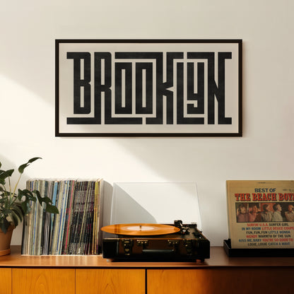 Retro Brooklyn artwork above vintage record player on Mid-Century Modern furniture.