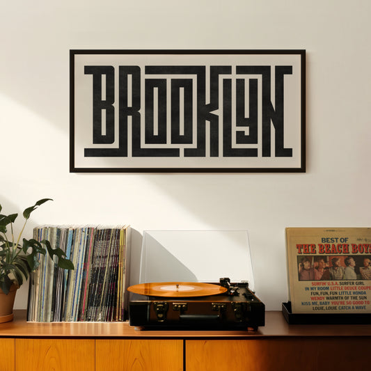Retro Brooklyn artwork above vintage record player on Mid-Century Modern furniture.