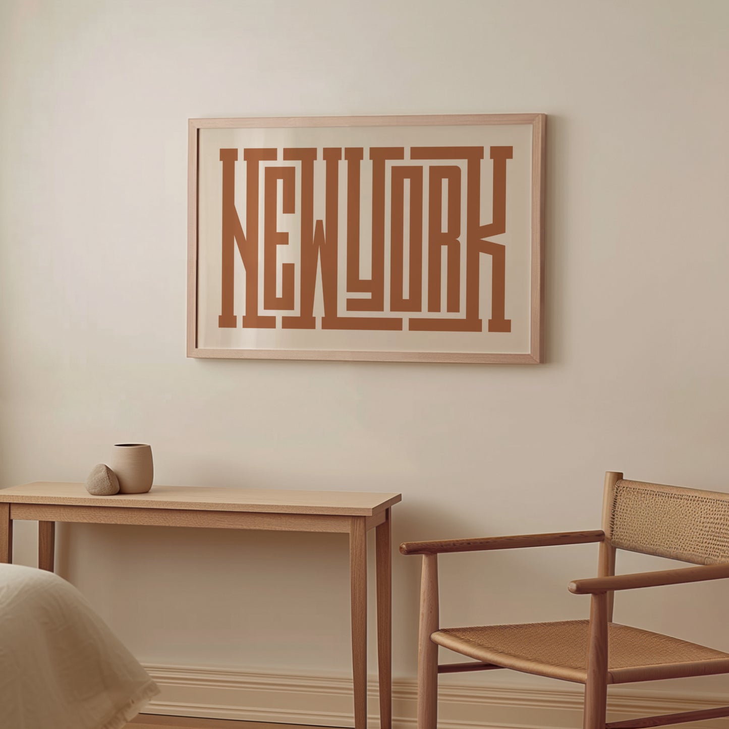 Boho Framed artwork with 'New York' on a wall above a wooden table and chair.