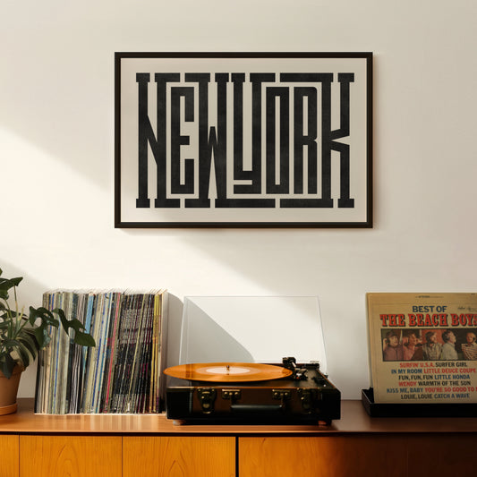 Framed artwork with 'New York' text above a record player and records on a wooden surface.