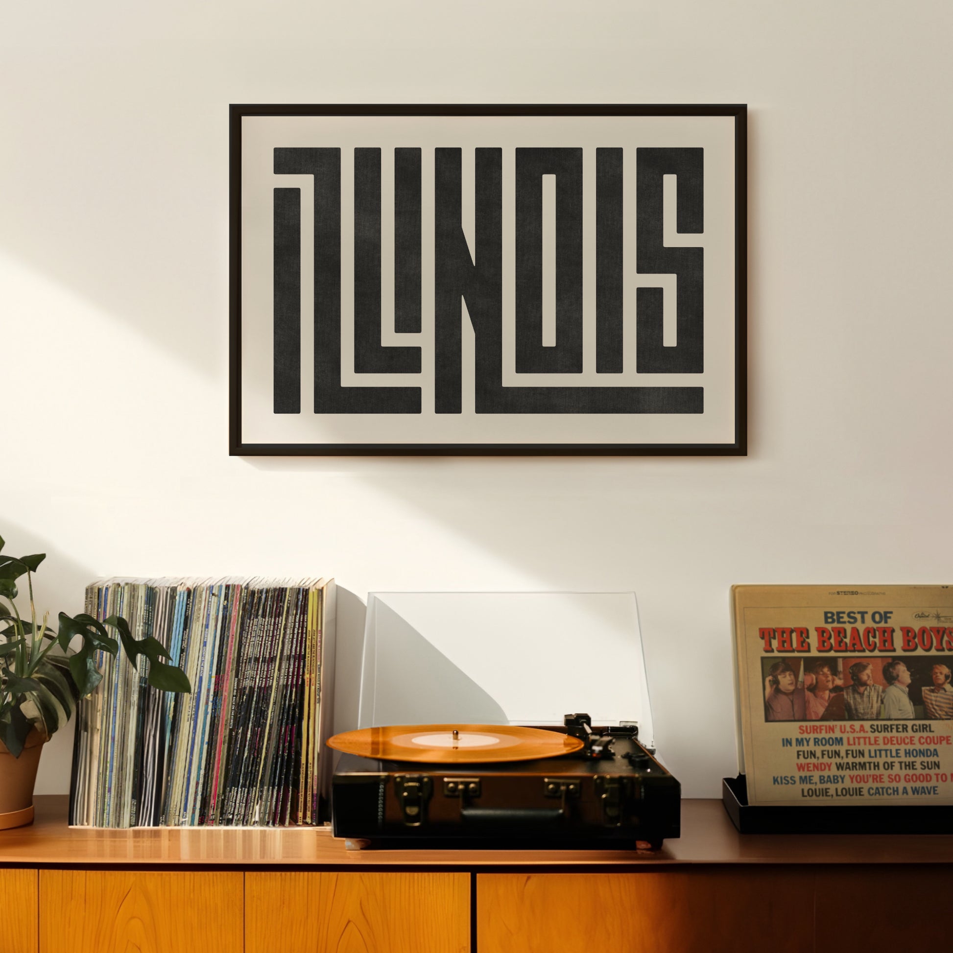 Retro Illinois artwork above vintage record player on Mid-Century Modern furniture.